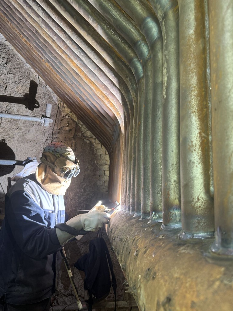 Soudeur au travail sur tuyauterie chaudière
